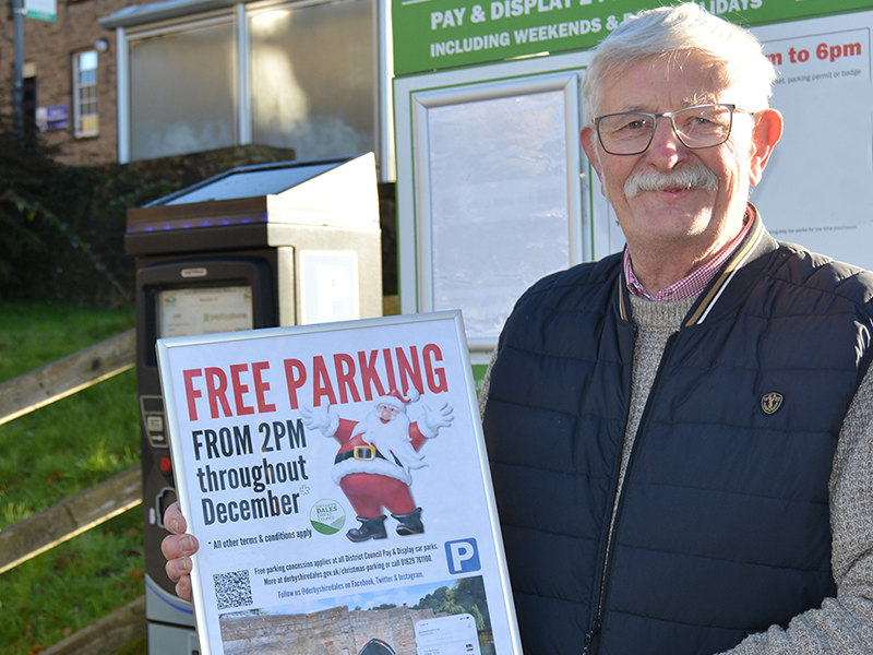 Council leader Councillor Steve Flitter promoting the free parking initiative with a poster at a car park machine