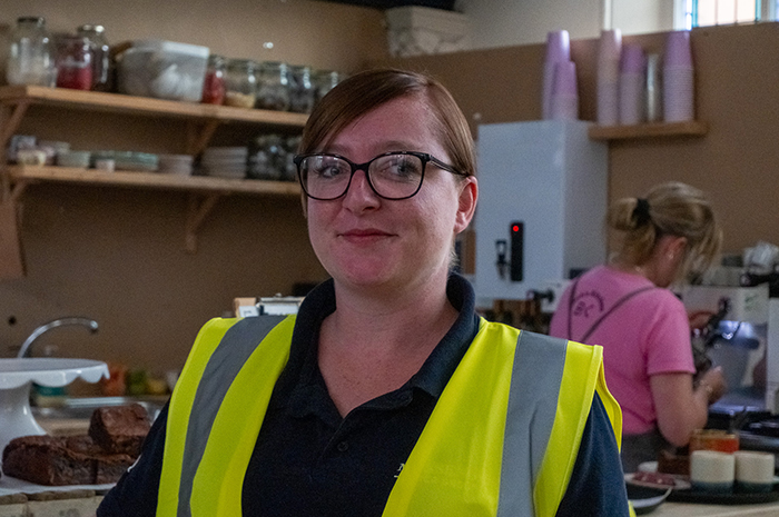Hayley Dawson stands in front of the temporary kitchen in a hi viz vest