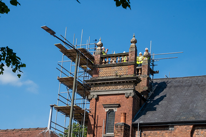 Scaffolding surrounds the church roof, small figures in hi viz can ben seen on the top