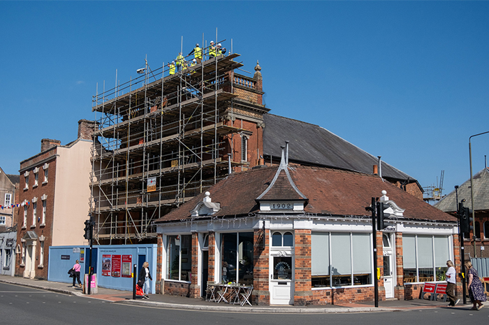 Side view of the church with scaffolding, small figures in hi viz can be seen at the very top
