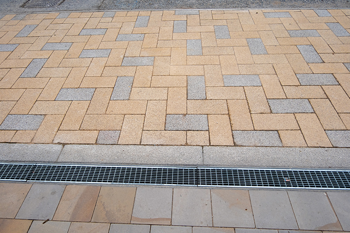 Small yellow and grey bricks contrast with Derbyshire stone paving to mark out the new loading bays